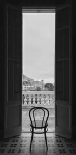 Chairs and table against sky seen through window