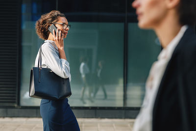 Side view of woman holding mobile phone