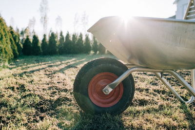 Front wheel of a wheelbarrow on a grass lawn at sunset