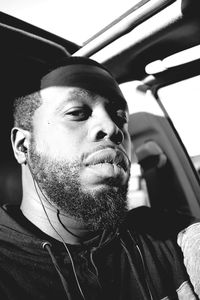 Close-up portrait of man listening music while sitting in car