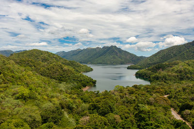 Lake and islands among mountains and hills against the blue sky and clouds. 