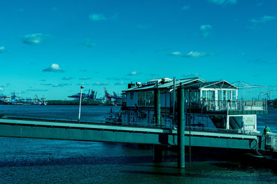 Bridge over sea against blue sky