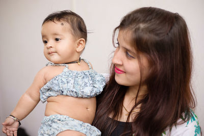 Young woman with niece against wall