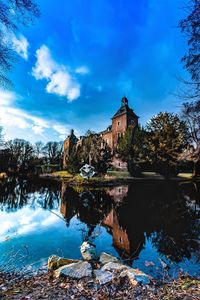 Reflection of building in lake against sky