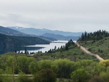 Scenic view of river by mountains against sky