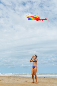 Rear view of woman with umbrella on beach