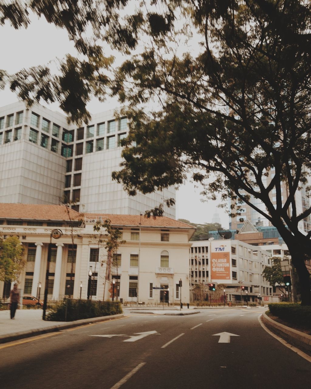 building exterior, architecture, built structure, street, city, road, tree, road marking, transportation, the way forward, building, car, residential building, residential structure, city life, sky, day, outdoors, diminishing perspective, incidental people