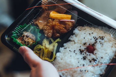 Cropped hand holding lunch box
