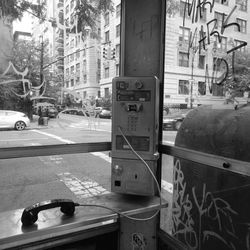 Old abandoned pay phone against building in city