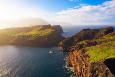 Scenic view of sea and mountains against sky