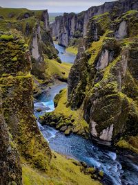 Scenic view of river flowing amidst rocks