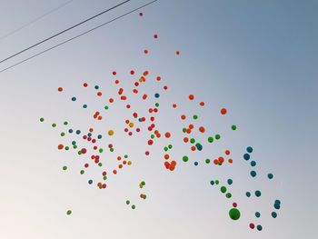 Low angle view of balloons against sky