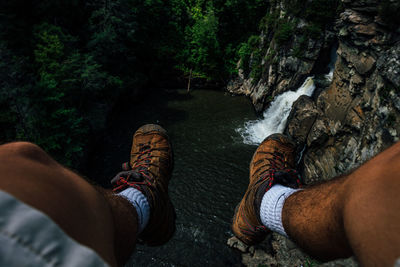 Low section of man by waterfall in forest