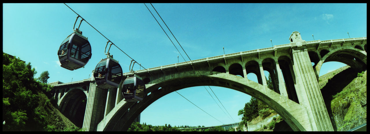 LOW ANGLE VIEW OF BRIDGE AGAINST CLEAR SKY IN CITY