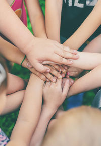 Low section of friends stacking hands