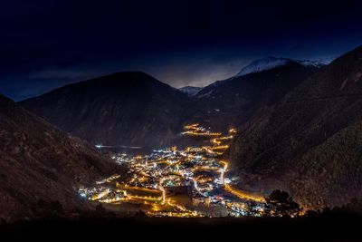 Illuminated cityscape against sky at night