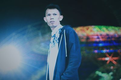 Portrait of young man standing at night