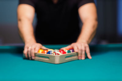 Midsection of man playing with toy blocks on table