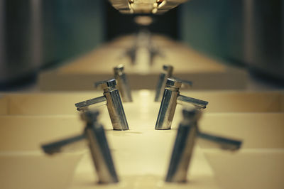 Row of faucets with reflection in restroom