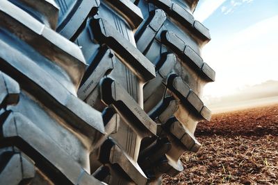 Close-up of stack of vehicle on field against sky