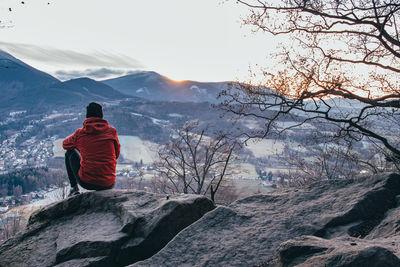 Rear view of man looking at mountain against sky