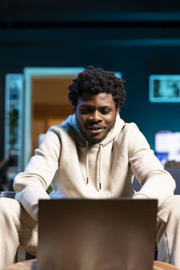 Portrait of young man using laptop at home