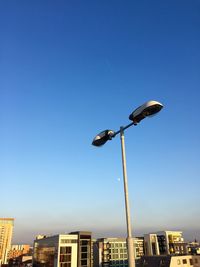 Low angle view of street light in city against sky