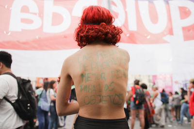 Rear view of people standing against blurred background