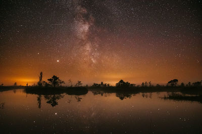 Scenic view of lake against sky at night