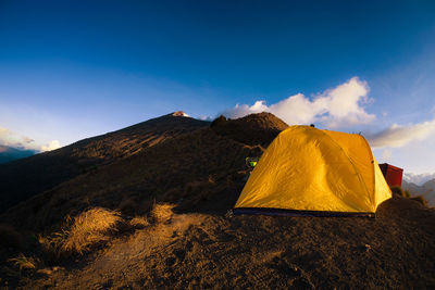 Tent on mountain against blue sky