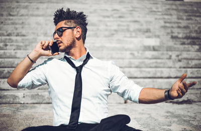 Young man sitting on wall