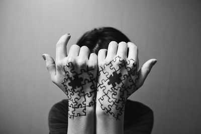 Close-up of human hands painted with jigsaw puzzle