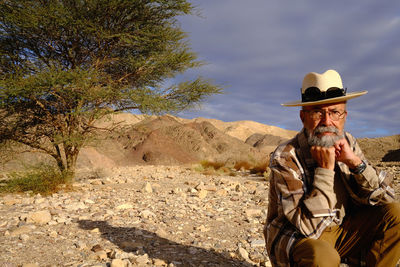 Portrait of senior man sitting in the desert 