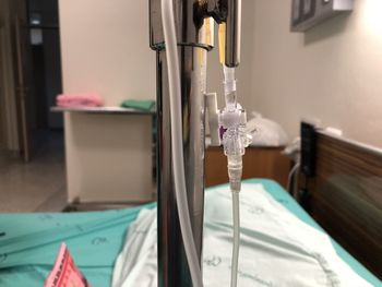 Close-up of iv drip by bed at hospital