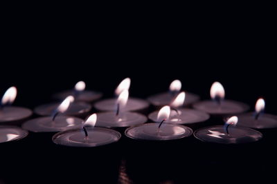 Close-up of lit candles on black background