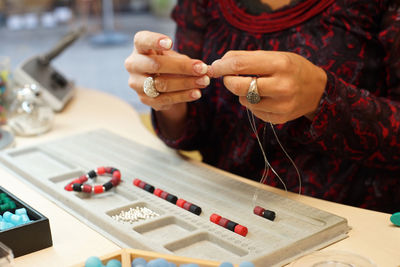 Midsection of woman making jewelry