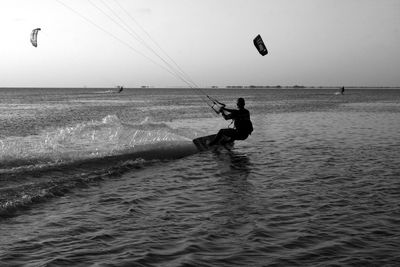 Man surfing in sea against sky