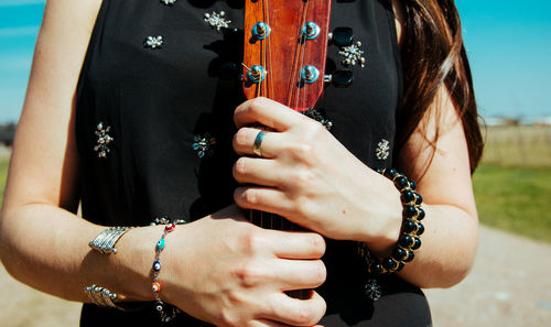 Midsection of woman holding guitar