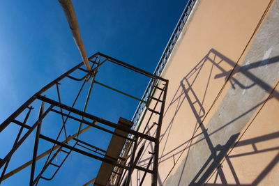 Low angle view of metallic structure against blue sky