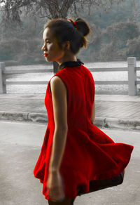 Side view of woman looking away while standing outdoors