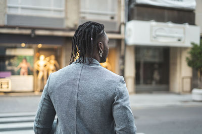 Rear view of young man standing in city 