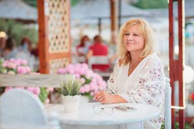 Portrait of woman sitting on the terrace of a beach cafe