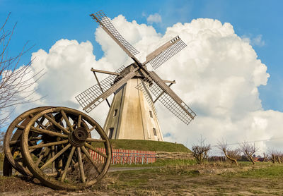 Traditional windmill on field against sky