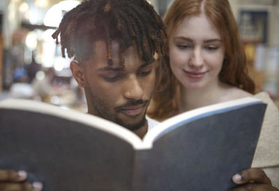 Portrait of young woman reading book