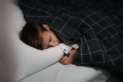 Boy sleeping on bed at home