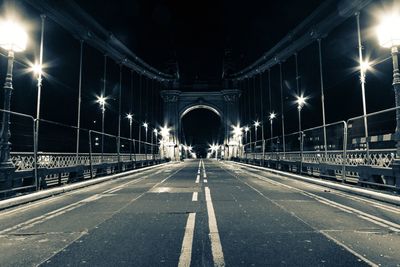 Illuminated bridge over road at night