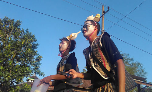 Low angle view people wearing costume and face paint against sky