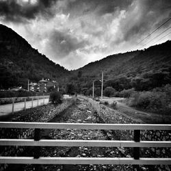 Railroad tracks leading towards mountain against sky