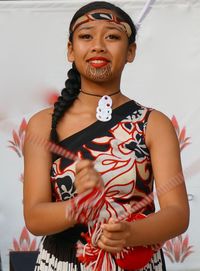 Portrait of beautiful young woman standing against wall