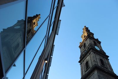 Low angle view of clock tower and building against clear sky